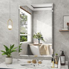 a bathroom with marble counter top and white bathtub next to a large mirror above the sink