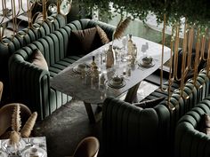 a long table surrounded by green velvet chairs