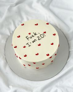 a white cake with red hearts and the words futt im 20 written on it