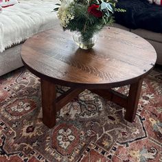 a vase with flowers on top of a wooden table next to a couch in a living room