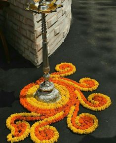 a metal lamp with orange and yellow flowers around it