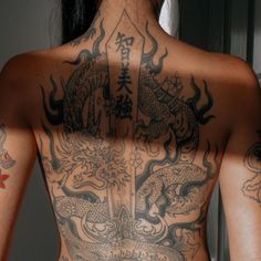 the back of a woman with tattoos on her body