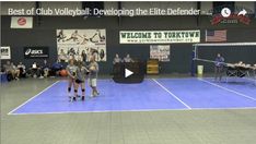 two women are playing volleyball on a court while people watch from the sidelines watching