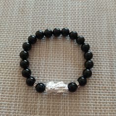 This Bracelet is made of Obsidian        beads with 925 Silver Pixiu. 14 k        Gp white Gold in the both side        of the Pixiu.  Pixiu is one of the most popular        Feng shui celestial Animal. Pixiu        is a symbol to protect wealth,       good fortune, Happiness and        luck will company with you.  Obsidian is negative energy and        help to prevent the drain of        personal energy. Also can help        your stress.  Pixiu size 20*10 mm. Obsidian beads 8 mm. Spiritual Obsidian Bracelet With Round Beads, Spiritual Obsidian Bracelets, Obsidian 8mm Beads Bracelet For Meditation, Hand-strung Obsidian Bracelet, Pixiu Bracelet, Personal Energy, Obsidian Bracelet, Feng Shui, 925 Silver