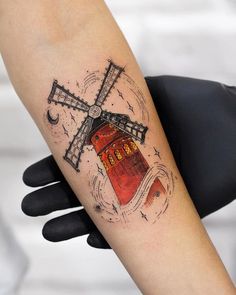 a person with a tattoo on their arm has a windmill in the middle of it