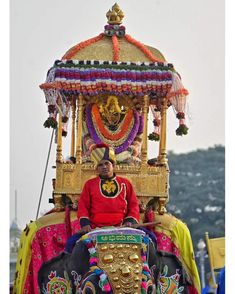 a man riding on the back of an elephant decorated with flowers and decorations in india