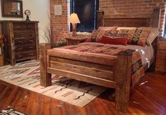 a bedroom with a brick wall and wooden furniture in the room, including a bed