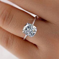 a woman's hand with a diamond ring on it