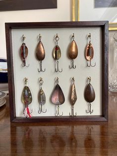 there are many different types of fishing lures in this shadow box on the table