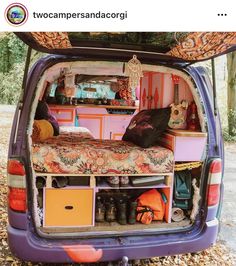 the back end of a van with its doors open and many items stacked in it