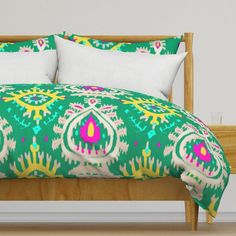 a bed with green and yellow bedspread, pillows and pillow cases on it