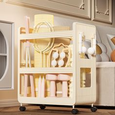 an assortment of bathroom items on wheels in front of a white cabinet with gold accents