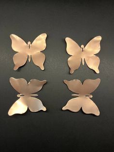 three metal butterflies sitting on top of a table