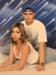 a man and woman posing for a photo in front of a blue background with stars