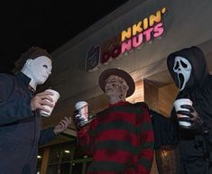 three people dressed up in halloween costumes holding cups