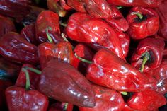 a pile of red peppers sitting next to each other