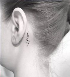 a woman's behind the ear with a musical note tattoo on her left side