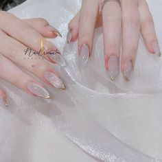 a woman's hands with long, shiny nails and gold glitters on them