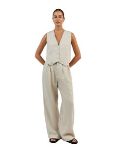 The Sleeveless Linen Vest Pant Set is a timeless ensemble that ties sophistication with comfort. This set is composed of a sleeveless linen vest that boasts a sharp V-neckline and button-down front, paired with coordinating wide-leg pants that offer a relaxed fit. This set encapsulates an effortless elegance, ideal for those who appreciate a minimalist aesthetic with a touch of classic charm! Features: Light & Soft Linen A lightweight textured linen material with soft lining adapts to any style