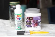 the supplies needed for painting are sitting on the table next to the jar and brush