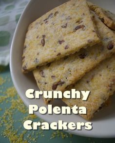 four crackers in a white bowl on a green tablecloth with the words crunchy polenta crackers