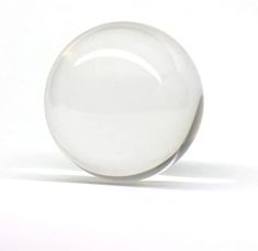 a glass ball sitting on top of a white surface