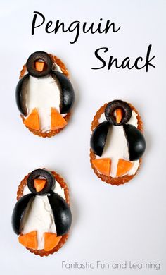 three penguin shaped cookies with icing on them and the words penguin snack written below