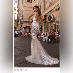 a woman in a white dress is standing on the street with her back to the camera