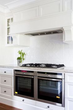 a stove top oven sitting inside of a kitchen next to white cabinets and counter tops