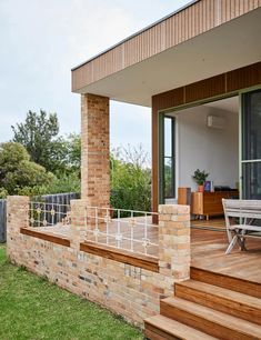 an outdoor deck with wooden steps leading up to the back door and dining table in the foreground