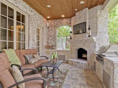 an outdoor living area with couches and grill