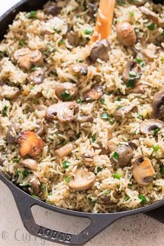 a skillet filled with rice and mushrooms