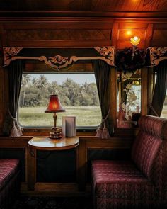 the inside of a train car with two couches and a table in front of it