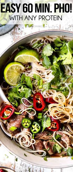 a bowl filled with noodles, meat and veggies on top of a table