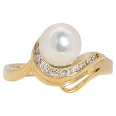 This elegant 18k yellow gold ring features a beautiful 6.75mm round brilliant cut Akoya pearl with a white color. The pearl is surrounded by 9 sparkling round brilliant cut diamonds, each weighing 0.13ct and with a G color and VS clarity. The ring has a total carat weight of 0.13ct and a total jewelry weight of 3.22g. The size of the ring is 50/11.5. This timeless piece of jewelry is perfect for any occasion. Metal: 18k Yellow Gold Main stone: 1 pc Akoya Pearl Size: 6.75mm Shape: Round Brilliant Akoya Pearl Ring, 18k Yellow Gold Ring, Akoya Pearls, Pearl Size, Round Brilliant Cut Diamond, Pearl Ring, Brilliant Colors, Yellow Gold Rings, Cocktail Rings