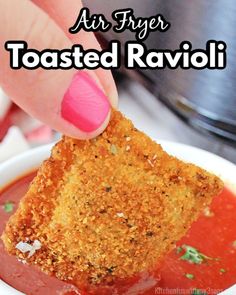 a person dipping some kind of food into a bowl with the words air fryer toasted ravioli above it