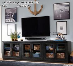 a living room with an entertainment center and pictures on the wall above it, along with a large flat screen tv