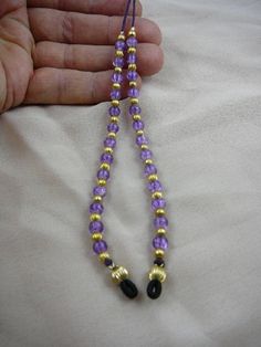 "(Internal #E-71) This is an eyeglass leash holder with round LIGHT PURPLE crackle glass beads (13 beads on each side) accented with round gold tone brass bead spacers, on purple cording, average 30\" long. Hand crafted and serve two purposes - they keep you from losing your glasses, and they look like earrings when you've got your glasses on! Loops slip on eyeglass arms, cording behind your neck. Keep your glasses on, or rest them on your chest - you've got them on a leash! Hand crafted and ONE Gold Single Strand Adjustable Glasses Chain, Gold Adjustable Single Strand Glasses Chain, Gold Beaded Glasses Chains, Gold Glasses Chains With Lobster Clasp And Round Beads, Handmade Gold Glasses Chains With Round Beads, Purple Choker, Eyeglass Necklace, Flower Choker Necklace, Silver Brooch Pin