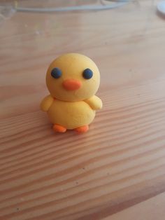 a yellow toy duck sitting on top of a wooden table