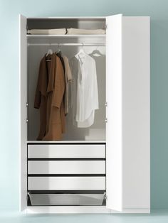 an open white wardrobe with clothes hanging on the rail and coat hangers in it