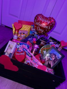 a valentine's day gift box with candy, candies and heart shaped balloons