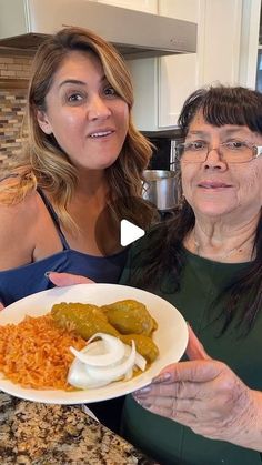 two women are holding a plate of food