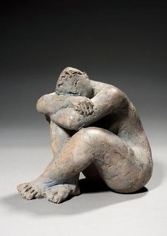 a sculpture of a seated man with his arms crossed and hands folded over his chest