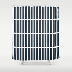 a blue and white shower curtain with vertical lines on it, in front of a gray background