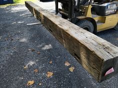 a forklift is parked next to a large wooden plank that has been cut into pieces