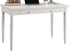 a laptop computer sitting on top of a white desk next to a stack of books