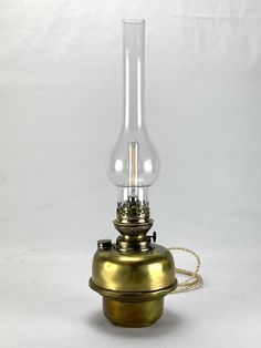 an antique brass oil lamp on a white background