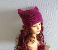 a mannequin head wearing a purple knitted hat with cat ears on it