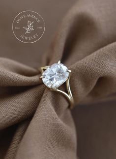 an engagement ring with a white topaz surrounded by brown fabric