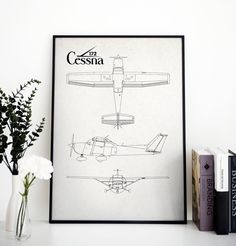 an airplane blueprinted on a white wall next to some books and a vase with flowers